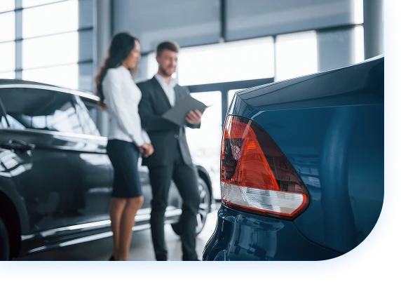 Salesperson talks with customer next to parked cars Salesperson talks with customer next to parked cars
