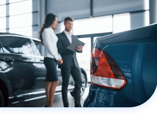 Salesperson talks with customer next to parked cars(mobile) Salesperson talks with customer next to parked cars